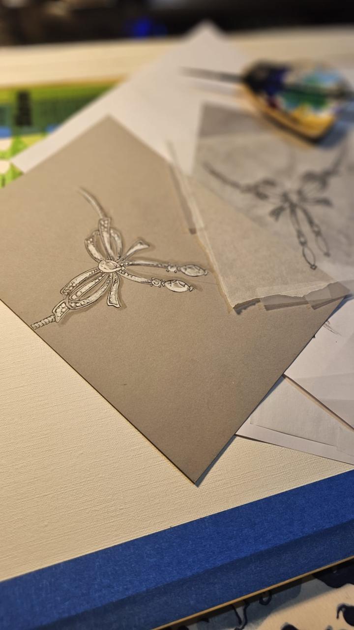 Hand-rendered jewelry sketch by Jennifer Derrig: vintage-style diamond bow necklace with drop accents on toned paper